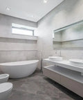 Modern bathroom with free-standing tub, double sinks, and wall-mounted fixtures.