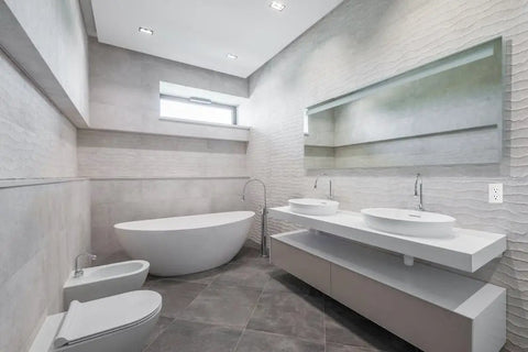 Modern bathroom with free-standing tub, double sinks, and wall-mounted fixtures.