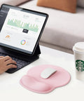 Light pink ergonomic gel wrist rest mouse pad on desk, 10.6 x 9 inch, paired with a mouse and non-slip base, for comfy work.