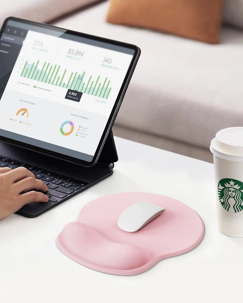 Light pink ergonomic gel wrist rest mouse pad on desk, 10.6 x 9 inch, paired with a mouse and non-slip base, for comfy work.