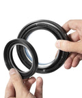 Hands holding seals from Ford Front Dana 50 60 Axle Seal Kit Beefed Up With Outer Dust Seal Inner Tube Seal Snap Ring Needle Bearing And Thrust Washer For 1998-2005 Ford Super Duty F250 F350 F450 F550 4X4 Off Road Ready
