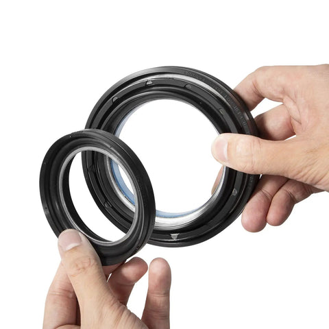 Hands holding seals from Ford Front Dana 50 60 Axle Seal Kit Beefed Up With Outer Dust Seal Inner Tube Seal Snap Ring Needle Bearing And Thrust Washer For 1998-2005 Ford Super Duty F250 F350 F450 F550 4X4 Off Road Ready