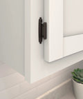 Variable Overlay Self Close Cabinet Hinges Oil Rubbed Bronze installed on a white cabinet door for smooth operation.