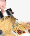 Beast Mode Heavy Duty 2000g Electric Grain Grinder Mill pouring beige powder near spices and herbs on wooden spoons