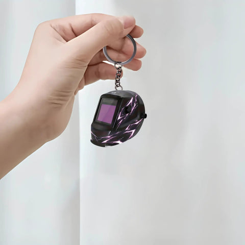 Hand holding a Lightning Pattern Welding Helmet Keychain with durable chain and ring, lightweight acrylic accessory, ideal for welders.