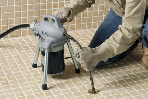 Pro Grade Sectional Drain Cleaning Machine With A Ready To Go Cable Kit For Three Quarter To Four Inch Lines Up To One Hundred Feet in use on a shower drain.