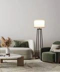 Tall 62 Inch Floor Lamp With Black Metal Base, White Fabric Drum Shade And 9W LED Bulb beside a sofa and armchair in living room