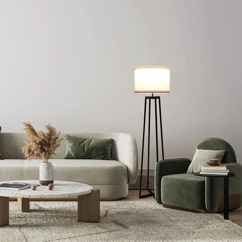 Tall 62 Inch Floor Lamp With Black Metal Base, White Fabric Drum Shade And 9W LED Bulb beside a sofa and armchair in living room