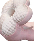 Close-up of Go-To Travel Napping Pillow With Face Cradle, pink ergonomic pillow showing textured surface for comfortable sleep.