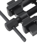 Close-up of a black carbon-steel two-jaw gear puller with a threaded screw