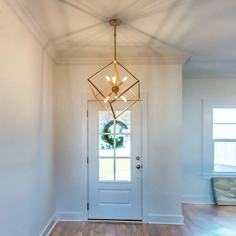 Gold Geometric Chandelier With Six Lights Modern Lantern Pendant Lighting hangs in foyer with white door, viewed from below.