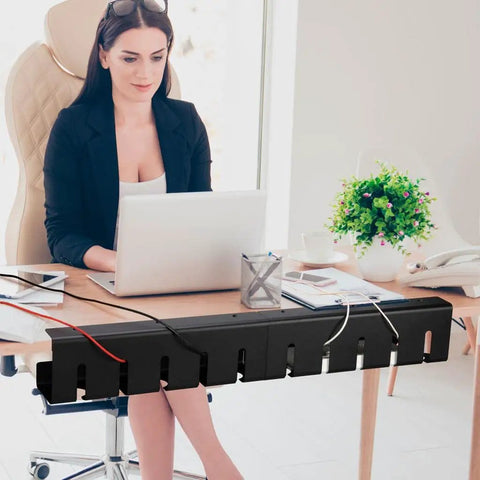 Black under desk cable management tray with adhesive, organizing cords in a modern office setup, perfect for standing desks.