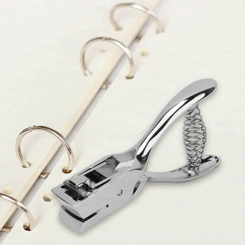 All Metal Handheld Hole Slot Puncher For ID Cards And Paper Crafts With 5.4 Inch Oval Punch And Spring Mechanism next to notebook