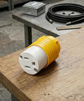Heavy Duty NEMA 5-15P To Dual Receptacle Adapter 15 Amp 125 Volt on wooden workbench with yellow connector.