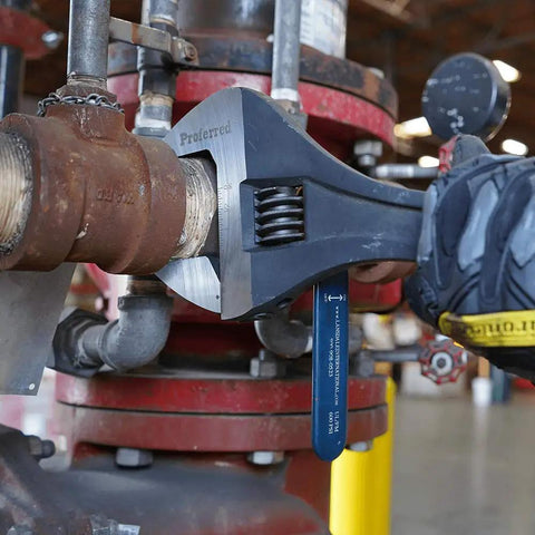 24 Inch Adjustable Wrench With Raised Head And Wide Grip For A Broad Range Of Fasteners, used on a pipe in an industrial setting.