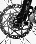 Close-up of a mountain bike disc brake caliper with hardened aluminum, showcasing smooth rotor design and cable assembly.