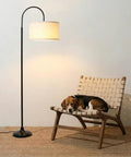 Nora Arc LED Tall Floor Lamp With Heavy Base For Living Room And Office next to chair with dog, sleek mid-century modern design