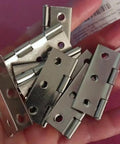 Heavy Duty Stainless Steel Flat Hinges With A Slick Silver Finish 20 Pack in hand showing details and pre-cut slots.