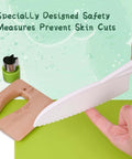 Side view of Kinggrand Montessori kitchen knife with white serrated blade and green handle on a green cutting board