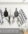 Three Piece Silicone Spoon Rest Set for stove top and kitchen counter hanging on hooks with striped towels