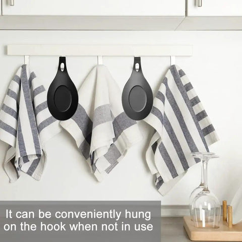 Three Piece Silicone Spoon Rest Set for stove top and kitchen counter hanging on hooks with striped towels