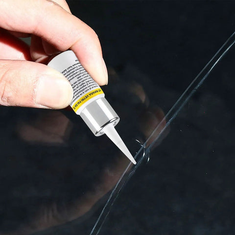 Hand applying Windshield Repair Kit With Nano Resin Fluid For Quick Fix Of Small Chips To Cracks on auto glass surface