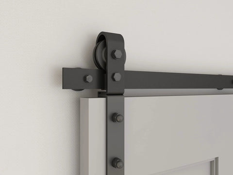 Close-up of heavy duty bi-fold barn door hardware kit with side mounted rollers on steel track, no doors, quiet sliding mechanism.