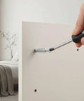 Screwdriver installing 15 Pack M6 X 35mm Furniture Connector Bolts And Dowel Screws in a white panel for DIY assembly