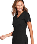 Woman wearing Women's Slim Fit V-Neck Scrub Top With 3 Pockets And Instrument Loop, Fade-Resistant Fabric, All-Day Stretch Knit, Black, Size M