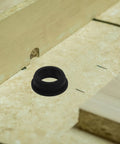 Top Tier 6 Pack Silicone Grommets For Wire Protection Shield Cables From Sharp Edges On Electrical Equipment And Hydroponic Systems With Universal Design For Any Gauge Cord. Black silicone grommet shown in wood panel cutout for wire protection.
