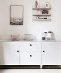 Minimalist white cabinet with Sleek Matte Black Cabinet Knobs Pack Of 25, Solid Round Drawer Knobs For Kitchen Cabinets, 1-1/4 inch diameter.