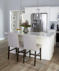 Kitchen island with Coastal Clear Glass Pendant Light in Matte Black 1 Light Ceiling Fixture above white countertop and chairs.