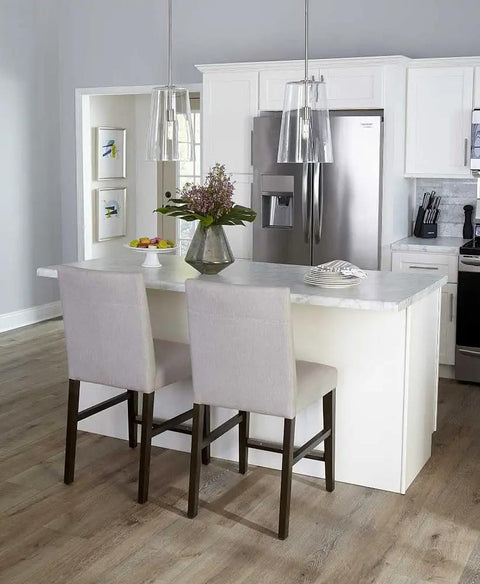 Kitchen island with Coastal Clear Glass Pendant Light in Matte Black 1 Light Ceiling Fixture above white countertop and chairs.