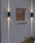 Modern Led Outdoor Wall Sconce,2-Pack 20w Updown Wall Wash Light,Black Metal Ip65 installed on a wall with bright light beams.