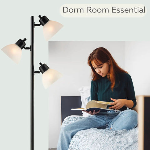 Three Light Black Floor Lamp Tree Style With Industrial Modern Look And Three Adjustable Heads For Ambient And Task Lighting A Tall Pole Lamp Built For Living Room Or Office And Ready To Shine Like A Boss next to a person reading on a bed.