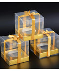 Golden Cake Gift Boxes 30 Pack With Clear Viewing Windows stacked with golden ribbons for premium dessert presentation