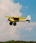 Carbon Cub S 2 1.3m RC Airplane BNF Basic With SAFE Technology flying in blue sky, yellow finish, 1.3m wingspan.