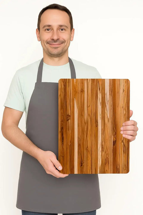 Killer Size Top Shelf Teak Wood Cutting Board 20X15 Inches Food Safe Kitchen Prep Station held by a man in an apron.