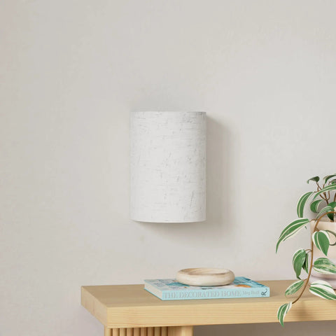 Set of Two Battery Rechargeable Wall Sconces With Remote Control in fabric finish, mounted above wooden shelf in living room.
