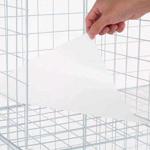 Hand placing shelf sheet in Premium Wire Cube Storage Organizer for home and garage, four cube shelving unit, DIY organizer.
