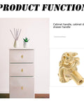 Close-up of vintage brass pig shaped drawer pulls on white cabinet, Chinese style decorative cabinet handles for small drawers.