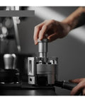 Hit Your Sweet Spot With This Heavy Duty Wdt Needle Distributor Engineered For 58mm Espresso Portafilters To Crush Stubborn Clumps And Elevate Your Roast Game, shown in use with a hand adjusting.