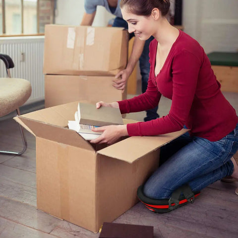 Knee Pads For Work With Soft Gel Core And EVA Foam Padding in use while unpacking boxes, ergonomic cushion for comfort, indoor setting.