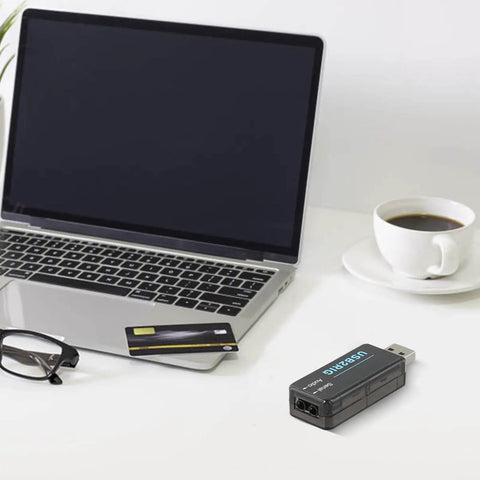 Compact USB Ham Radio Audio Interface With PTT Control For Yaesu And ICOM next to a laptop and coffee cup on a white desk.