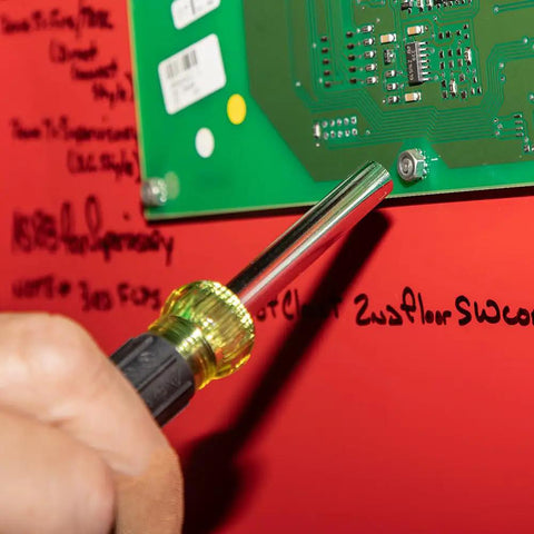 Hand using 14-In-1 Electronic Precision Screwdriver Kit With 8 Tips Slotted Phillips And Tamperproof Torx Bits on circuit board