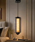 Alabaster Pendant Lights, Smoky Gray Glass Pendant Light Fixtures hanging over a bedside table with soft illumination.