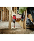 Person using Built Dang Tough 12 Volt Cordless Drill And Driver with brushless motor to drill into wood at a construction site.