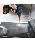 Bosch IMC500 cordless drill with bit drilling into metal surface; blue 18V tool