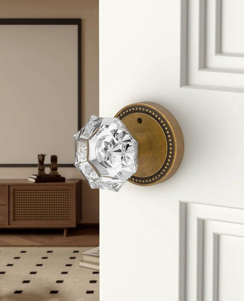 Close-up of 6 Pack Privacy Antique Brass Crystal Door Knobs With Lock For Bedroom Or Bathroom installed on white door