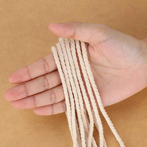 Hand holding 4mm Natural Cotton Macrame Rope Twisted 3-Strand Cord, 328 Yards for wall hangings, plant hangers, DIY crafts.